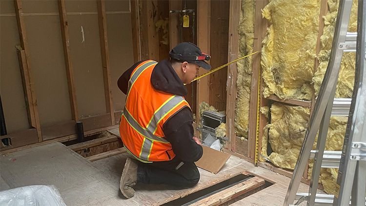 Royal Flush plumber measuring a wall for a whole-home repipe